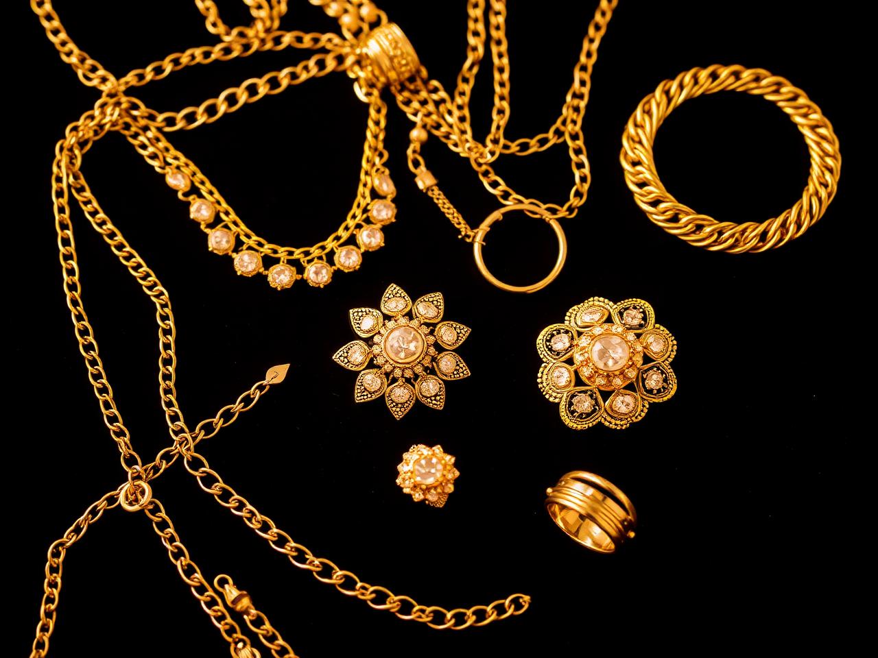 Gouden ringen, schakelketting, munt en goudbaar klaar voor taxatie — goud inkoop volendam en omgeving
